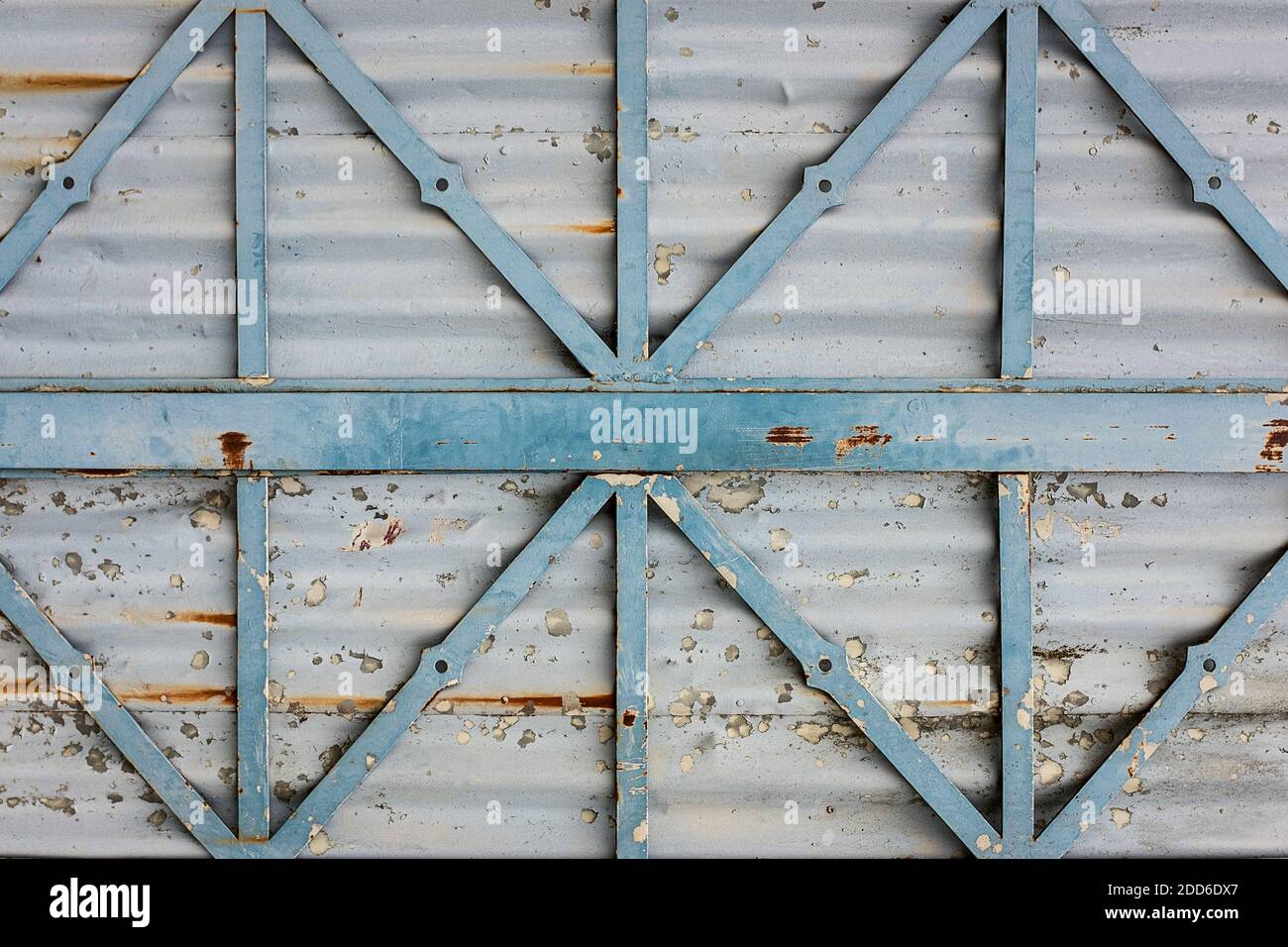 texture d'une surface métallique grise rouillée avec des jambes de force en métal bleu clair, peinture écaillée Banque D'Images