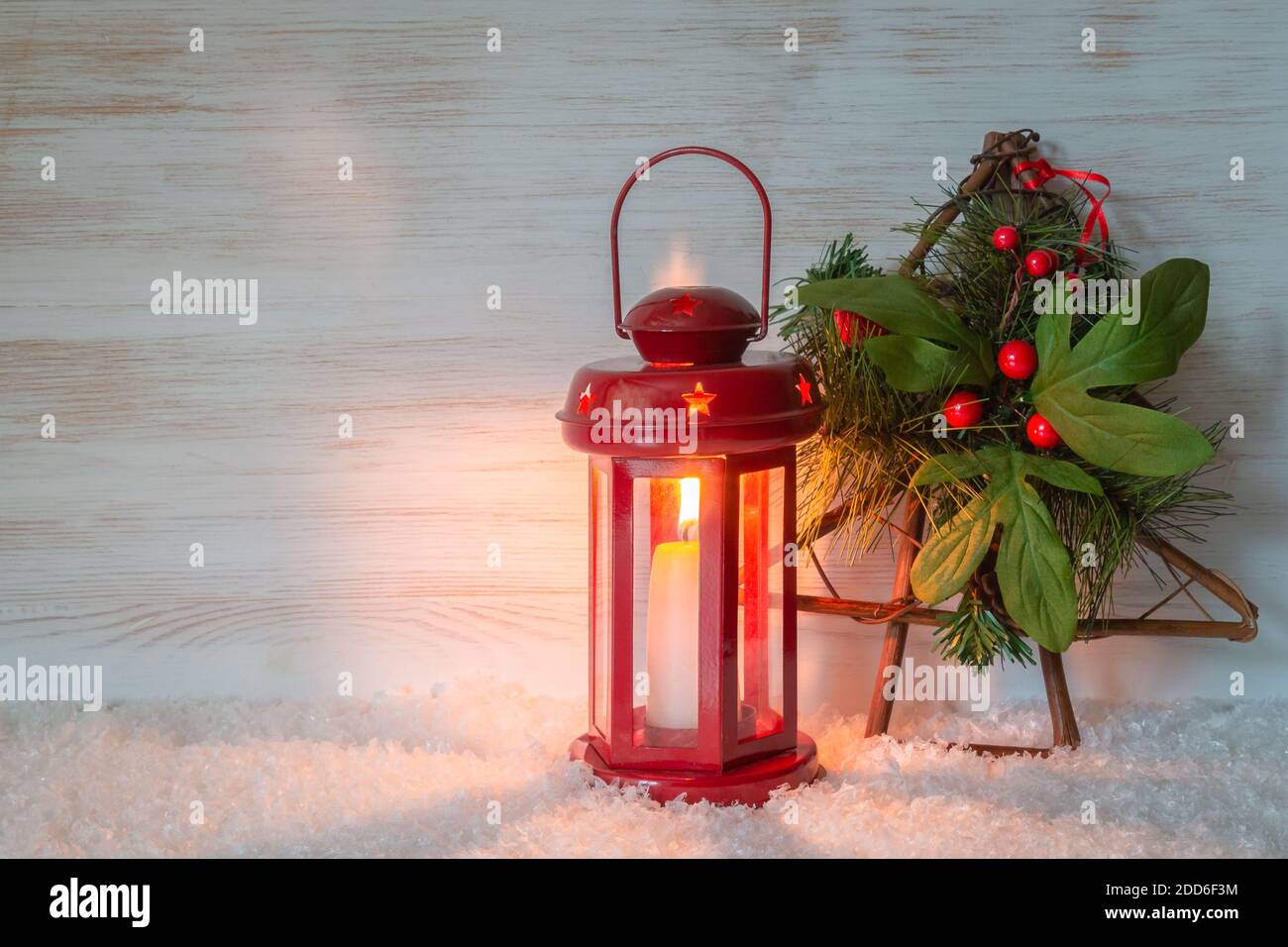 Arbre de Noël aux baies, bougie rouge brûlante sur fond de lanterne en bois pour l'espace de copie. Décoration d'ambiance de Noël Banque D'Images