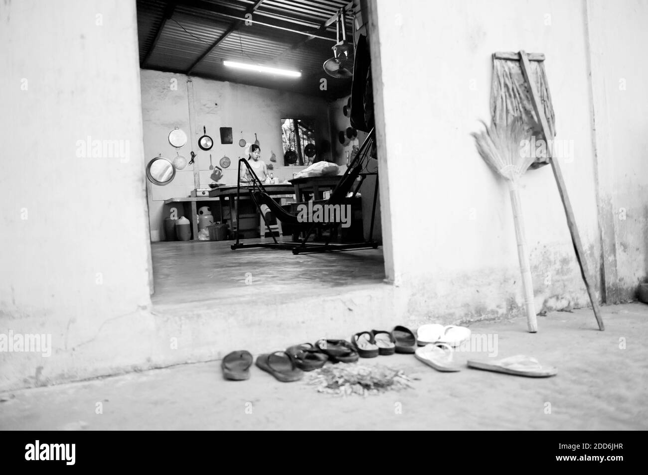 Noir et blanc photo de chaussures laissées à l'extérieur de la cuisine à un Homestay dans le delta du Mékong, Vietnam, Asie du Sud-est Banque D'Images