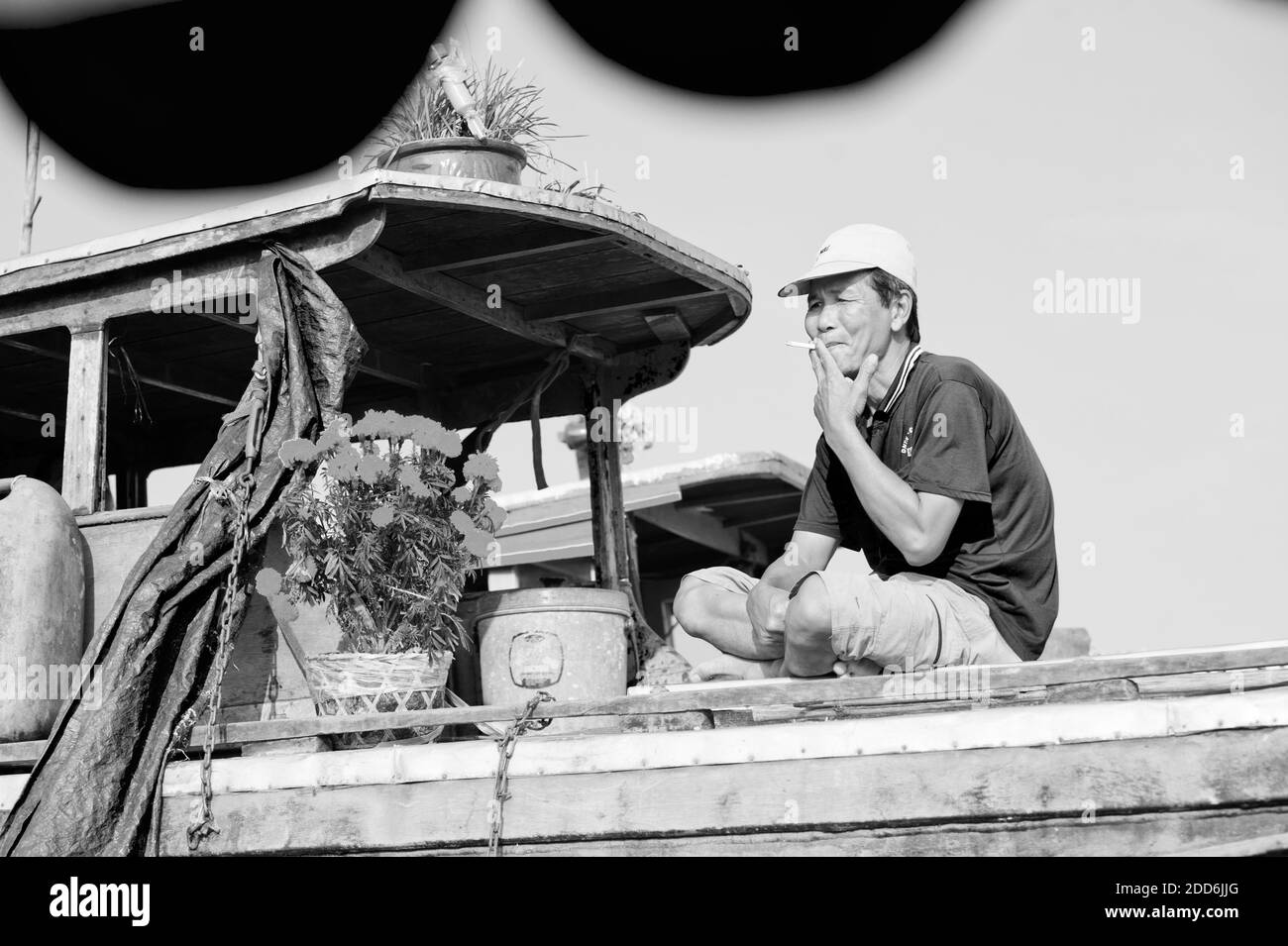 Noir et blanc photo d'un propriétaire de bateau prenant une pause au marché flottant CAN Tho, Delta du Mékong, Vietnam, Asie du Sud-est Banque D'Images