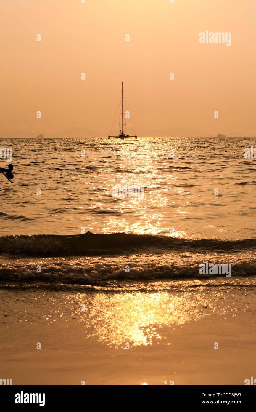 Catamaran silhouetté à Sunrise Off East Railay Beach, sud de la Thaïlande, Asie du Sud-est Banque D'Images