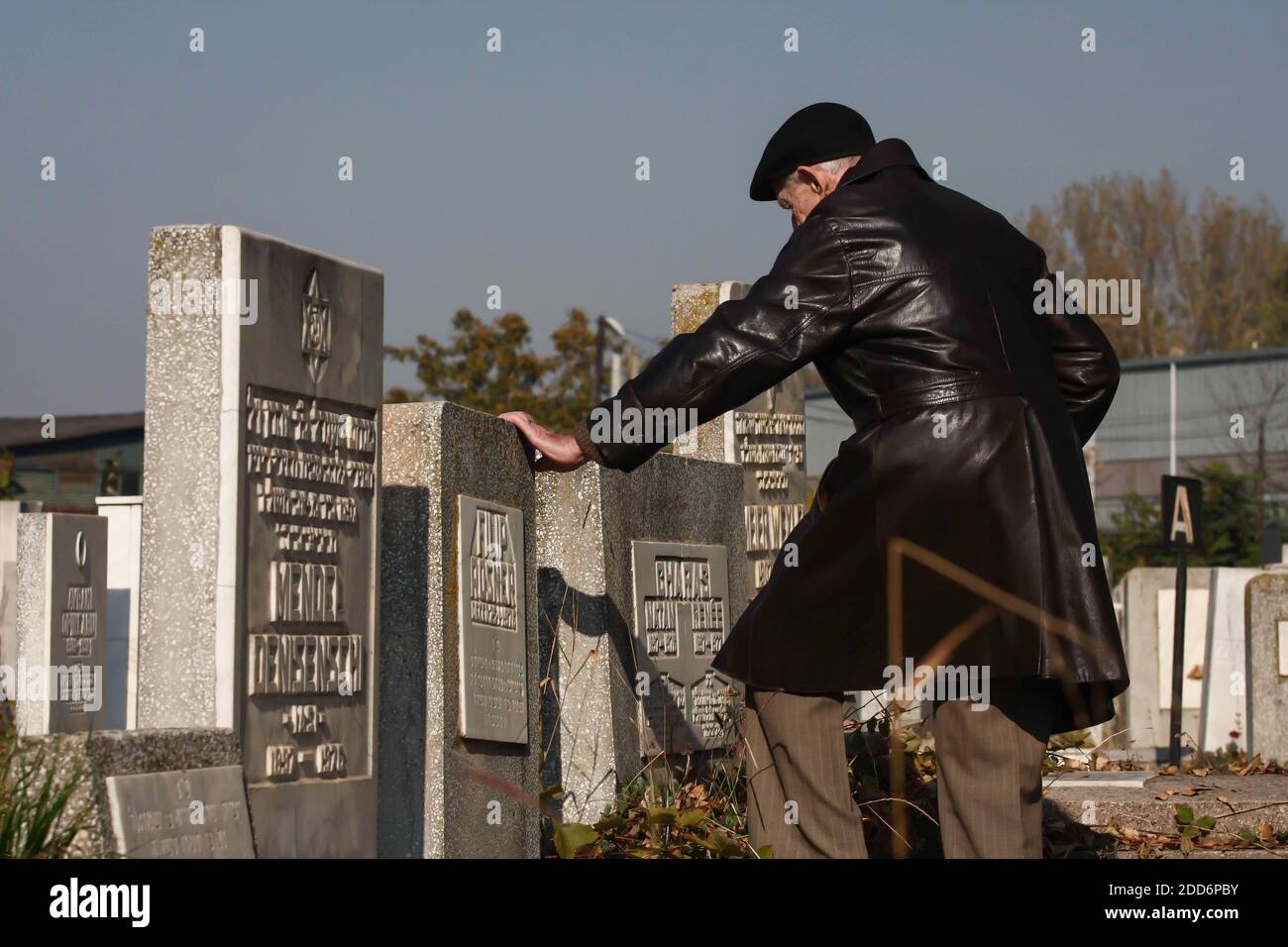 Bucarest, Roumanie - 29 octobre 2008 : un homme âgé touche une tombe d'un cimetière juif de Bucarest. Banque D'Images