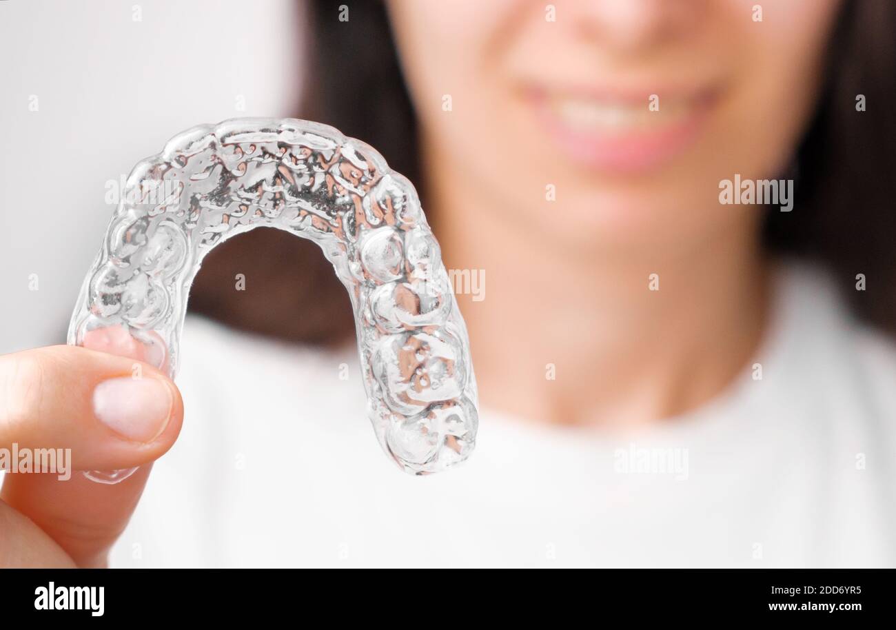 Gros plan orthodontique alignement transparent dans la main des femmes. Bretelles amovibles. Banque D'Images