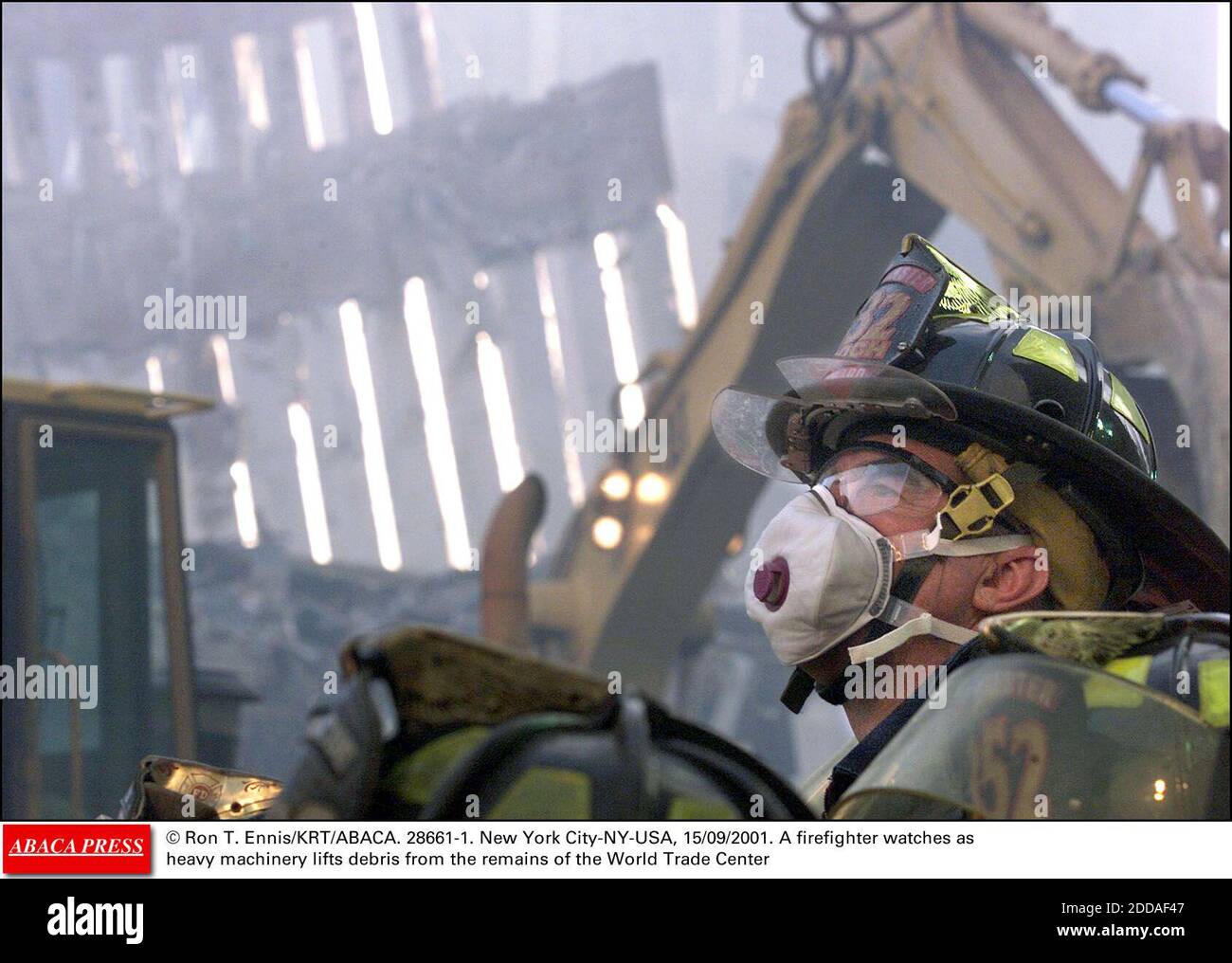 PAS DE FILM, PAS DE VIDÉO, PAS DE TV, PAS DE DOCUMENTAIRE - © RON T. ENNIS/KRT/ABACA. 28661-1. New York City-NY-USA, 15/09/2001. Un pompier observe que des machines lourdes soulèvent des débris des vestiges du World Trade Center Banque D'Images PAS DE FILM, PAS DE VIDÉO, PAS DE TV, PAS DE DOCUMENTAIRE - © RON T. ENNIS/KRT/ABACA. 28661-1. New York City-NY-USA, 15/09/2001. Un pompier observe que des machines lourdes soulèvent des débris des vestiges du World Trade Center Banque D'Images
