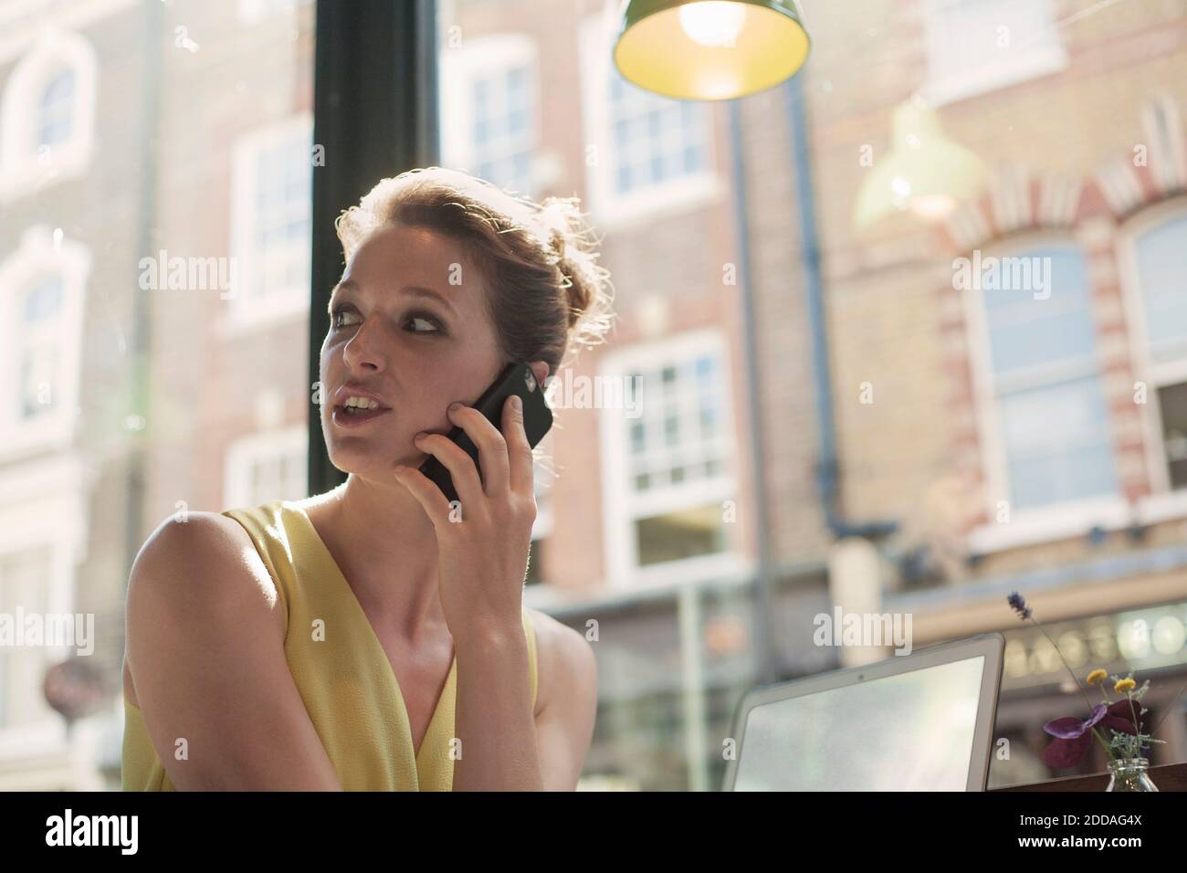 Une jeune femme d'affaires parle au téléphone portable dans un café Banque D'Images