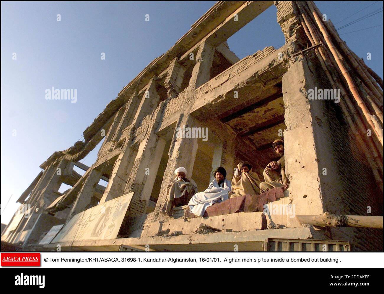 PAS DE FILM, PAS DE VIDÉO, PAS DE TV, PAS DE DOCUMENTAIRE - © TOM PENNINGTON/KRT/ABACA. 31698-1. Kandahar-Afghanistan, 16/01/01. Des hommes afghans sirotent du thé à l'intérieur d'un bâtiment bombardé. Banque D'Images