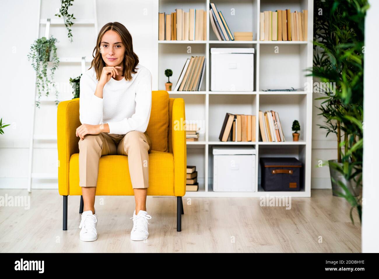 Jeune femme d'affaires assise avec la tête dans les mains sur le canapé à bureau Banque D'Images