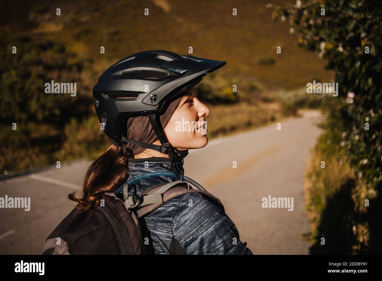 Femme portant un casque de cyclisme debout sur le sentier de montagne au parc naturel de Somiedo, Espagne Banque D'Images