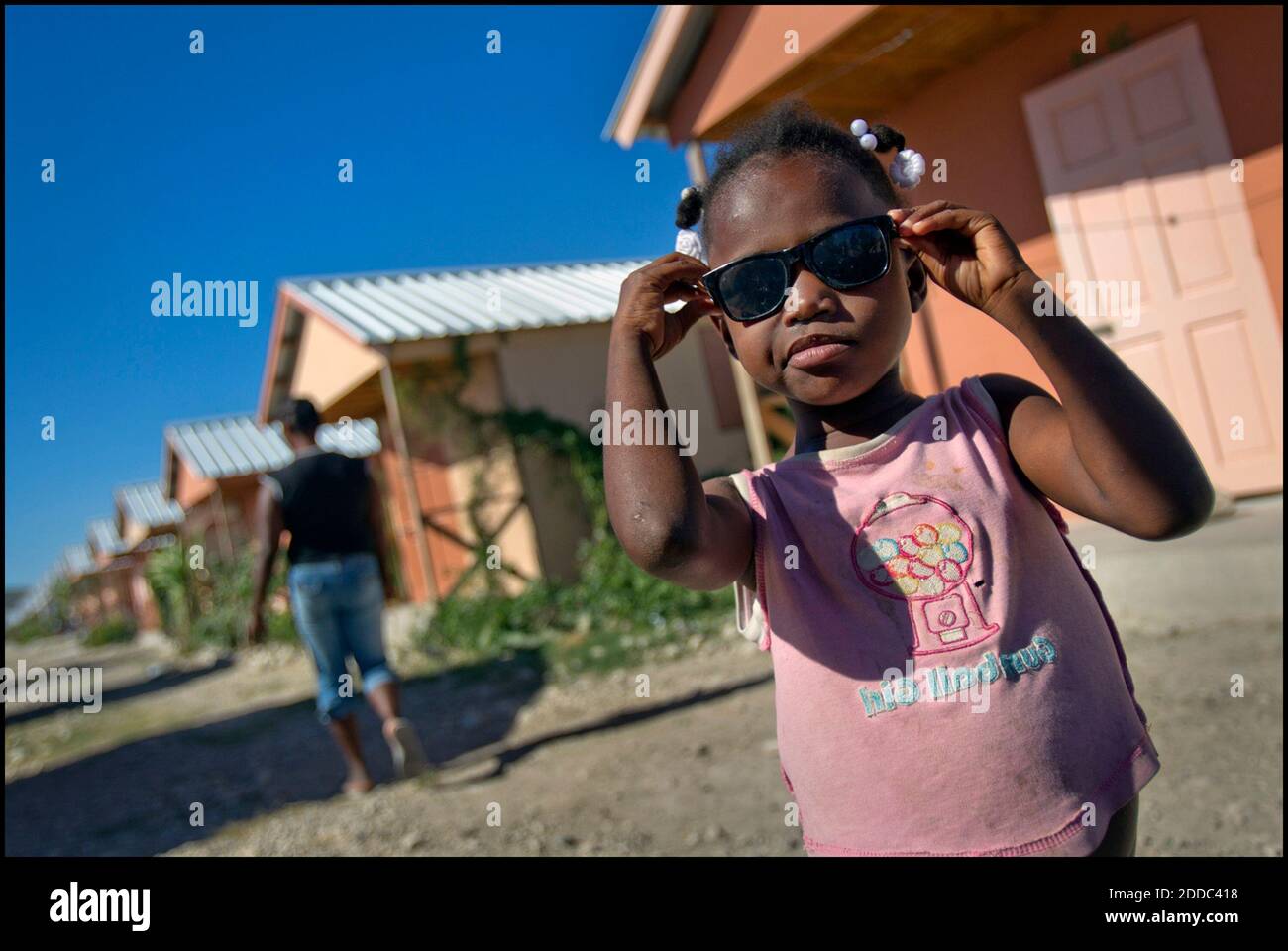 PAS DE FILM, PAS DE VIDÉO, PAS de TV, PAS DE DOCUMENTAIRE - Shirley Lenord,  6 ans, essaie des lunettes de soleil à l'extérieur de la petite maison de  sa famille à