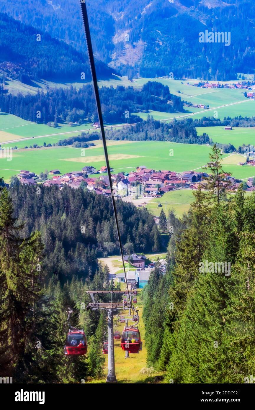 Autriche, Tyrol, Gran, remontée mécanique à Tannheimer Tal avec village en arrière-plan Banque D'Images