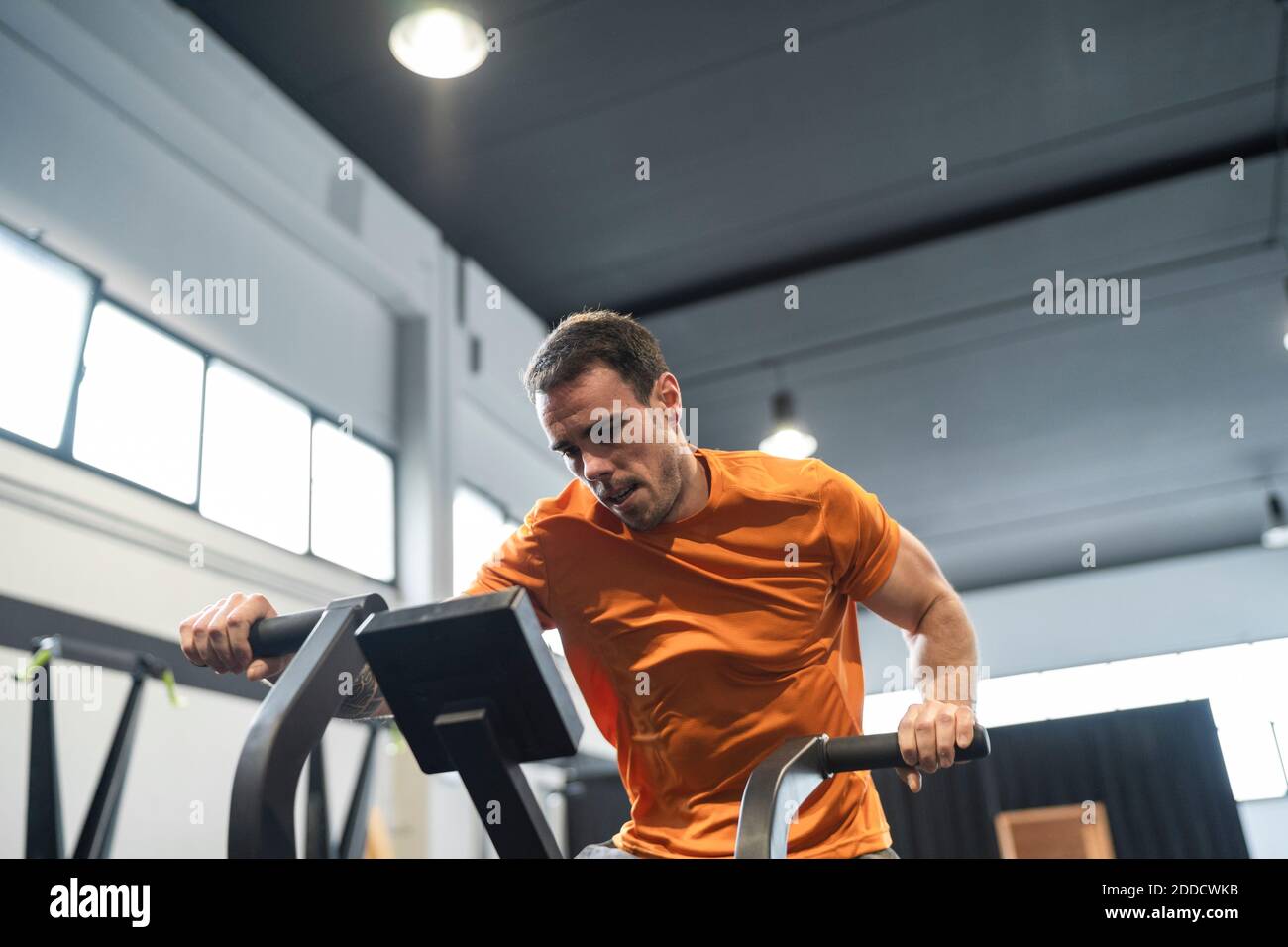 Athlète masculin s'entraînant sur l'équipement d'exercice dans la salle de gym Banque D'Images