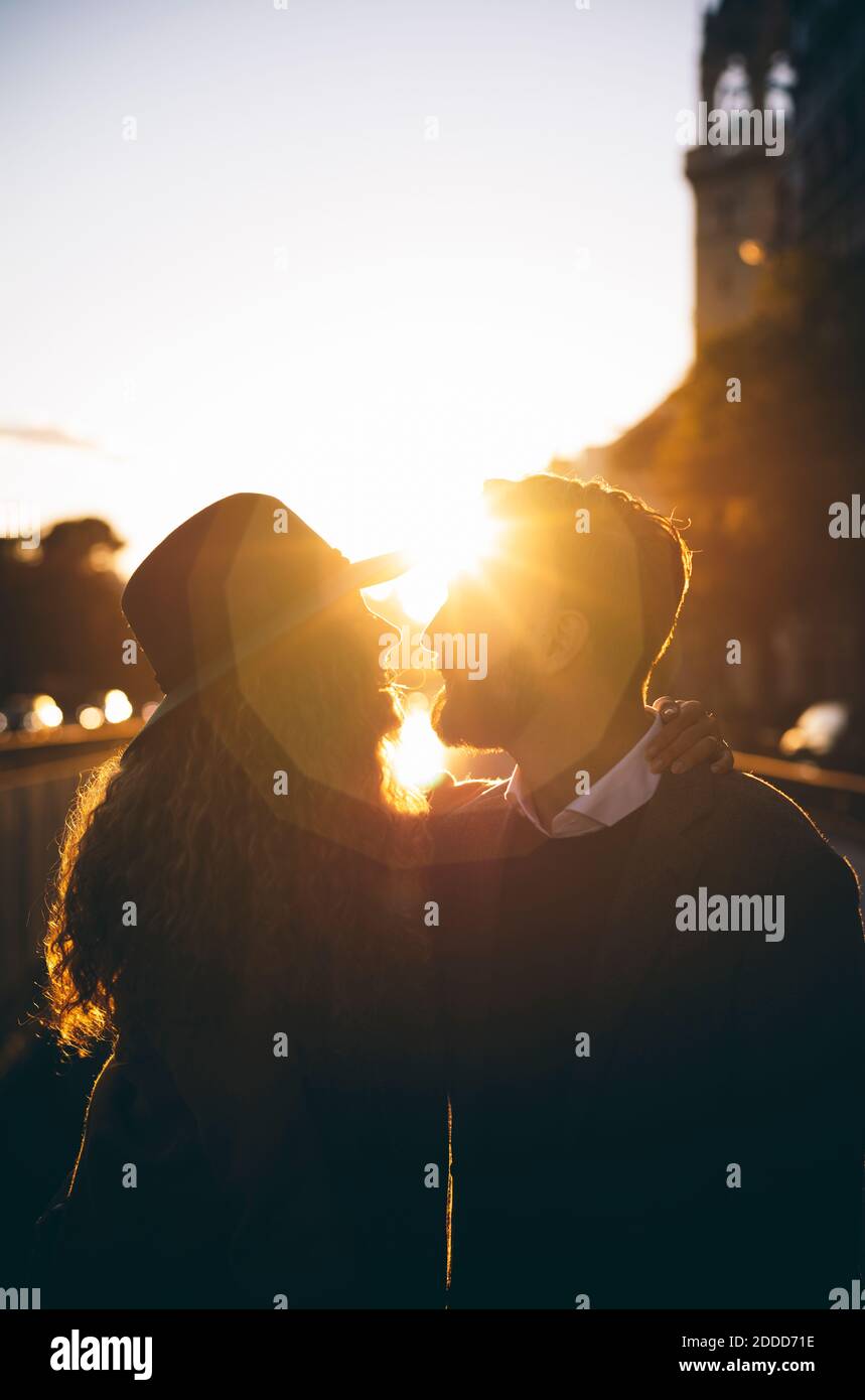 Silhouette de couple debout avec le bras autour dans la ville Banque D'Images