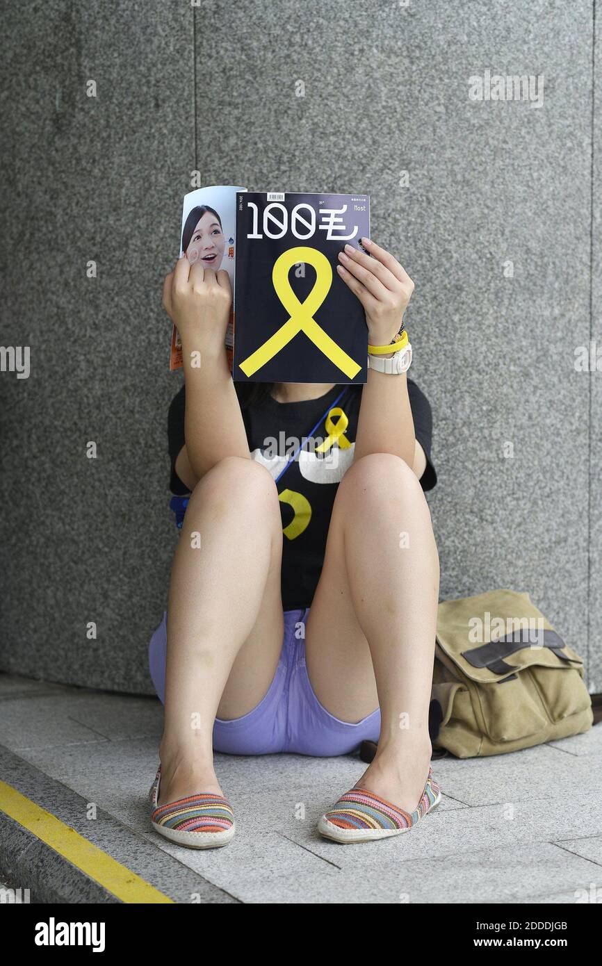 PAS DE FILM, PAS DE VIDÉO, PAS de télévision, PAS DE DOCUMENTAIRE - un manifestant non identifié se détend pendant le sit-in, lisant une brochure avec le ruban jaune symbole de la manifestation sur sa couverture (et apposé sur sa chemise) à Hong Kong, Chine le 2 octobre 2014. Photo de Chris Stowers/McClatchy/MCT/ABACAPRESS.COM Banque D'Images