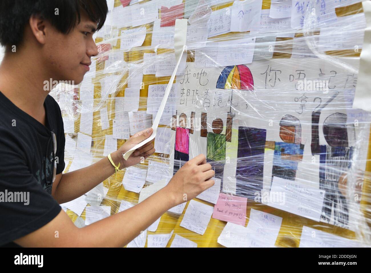 PAS DE FILM, PAS DE VIDÉO, PAS de TV, PAS DE DOCUMENTAIRE - Philip Yeung, 17 ans, conservateur étudiant du mur de messages, organise des messages à Hong Kong, Chine, le 2 octobre 2014. Le mur des messages près du siège social du gouvernement de Hong Kong à Admiralty contient plus de 4,000 messages et continue d'attirer des commentaires de gens du monde entier. Photo de Chris Stowers/McClatchy/MCT/ABACAPRESS.COM Banque D'Images