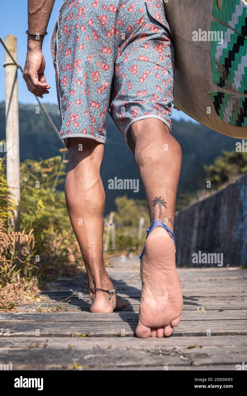 Jeune homme marchant sur la promenade à la plage Banque D'Images