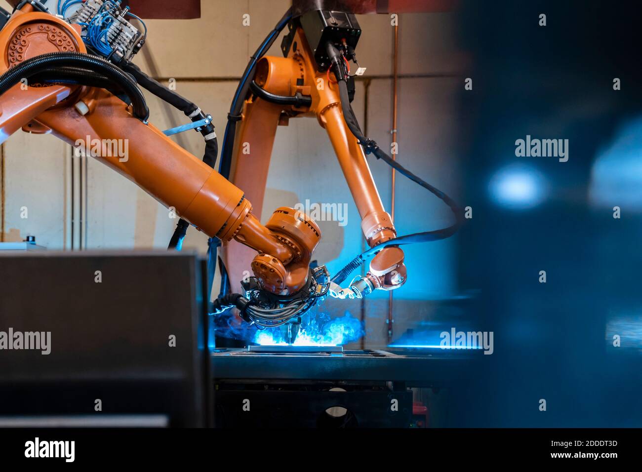 Fabrication de bras robotisés de couleur orange dans une usine industrielle Banque D'Images