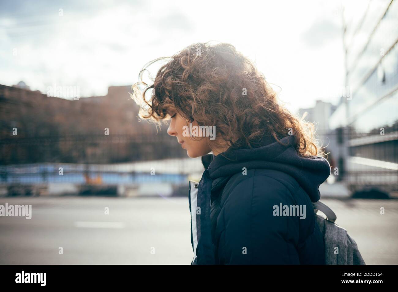 Femme avec les yeux fermés debout par la route à la ville Banque D'Images