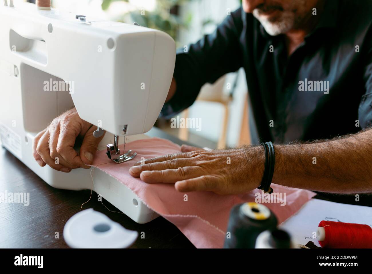 Homme designer de costume couture de tissu tout en travaillant en studio Banque D'Images