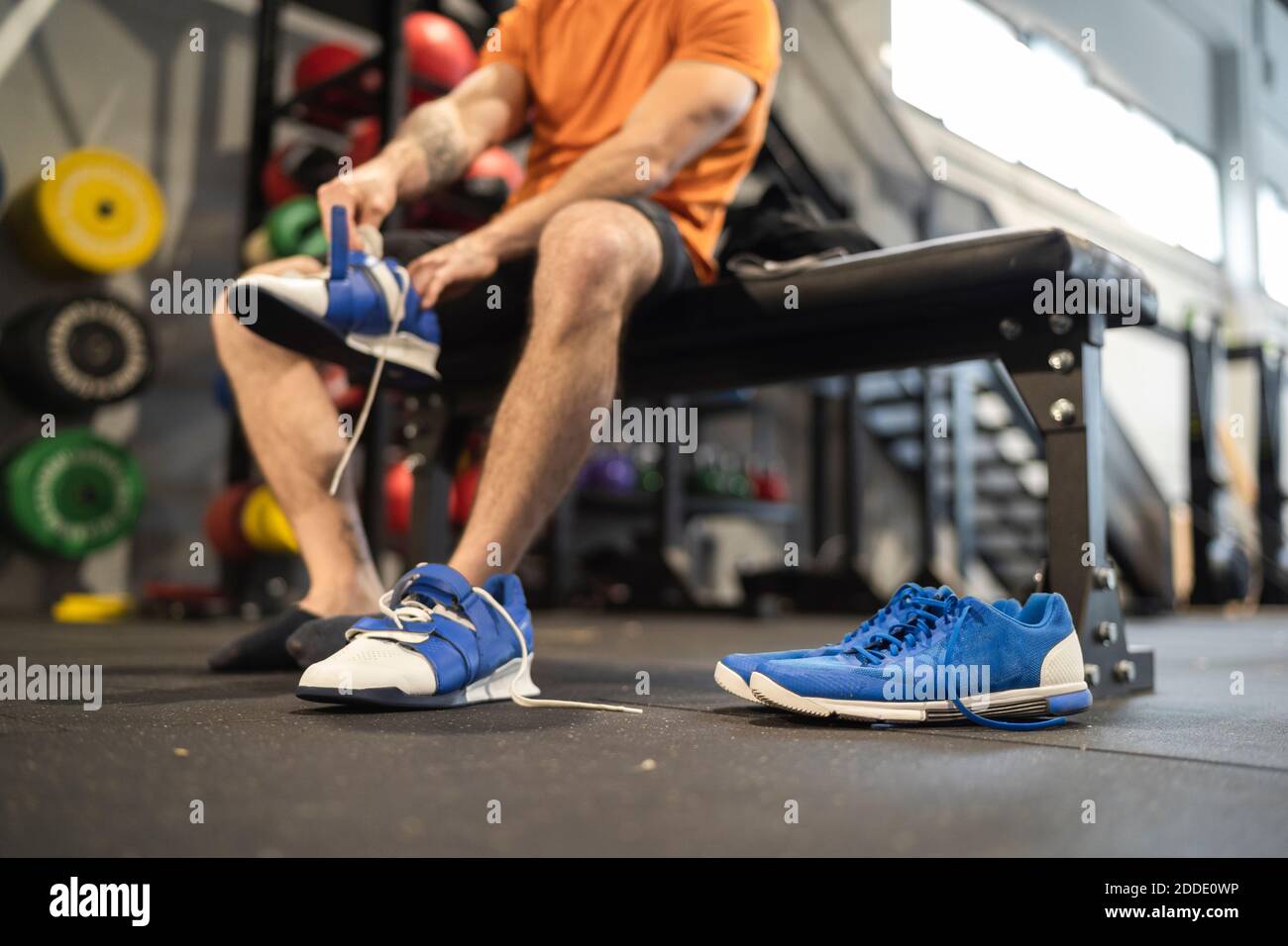 Athlète masculin portant une chaussure de sport en salle de sport Banque D'Images