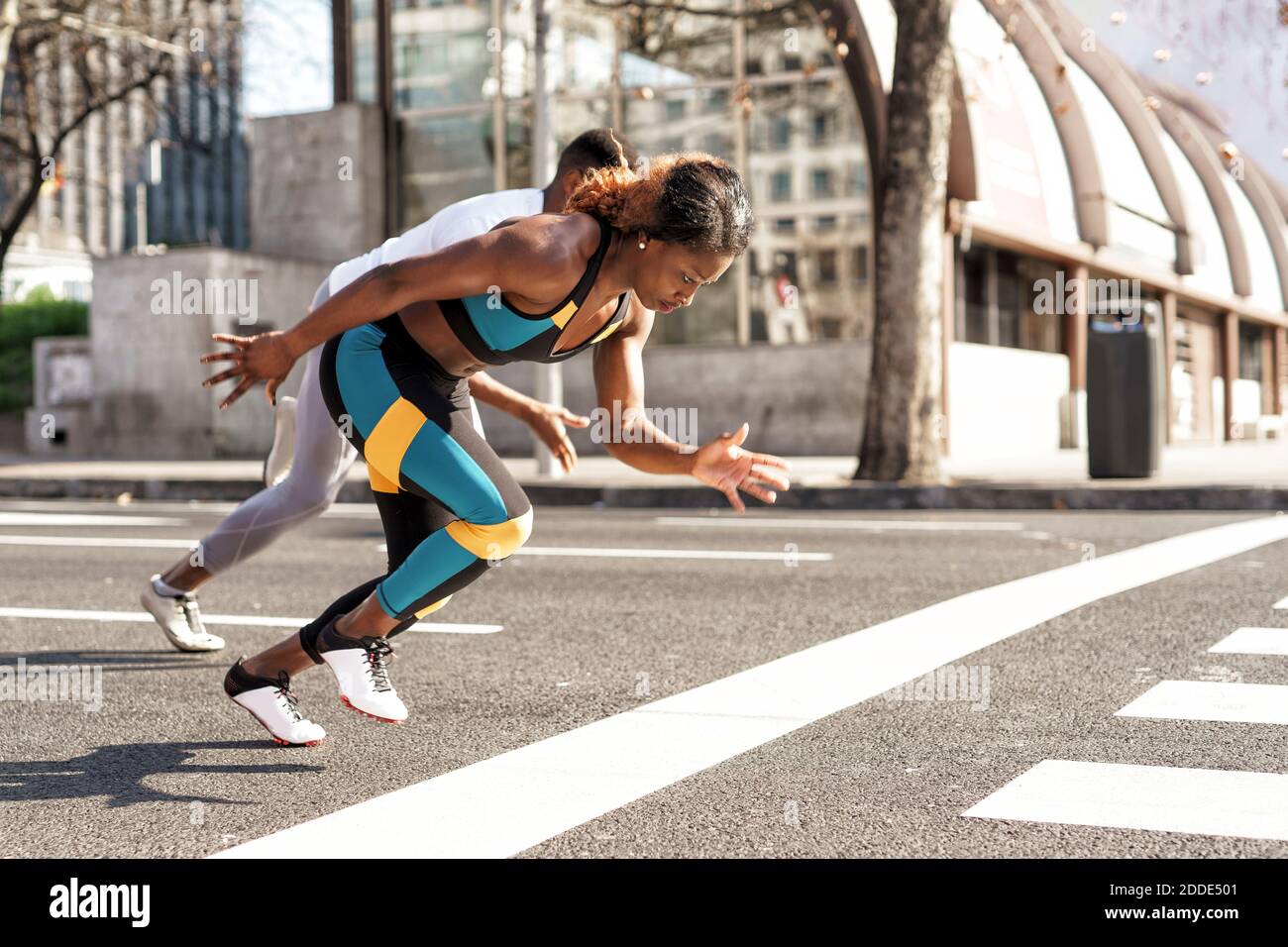 Jeune homme et jeune femme pratiquant la course sportive pendant la course à pied en ville Banque D'Images