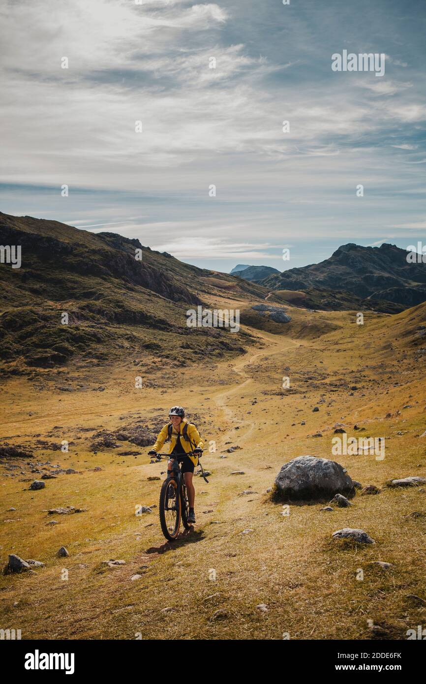Femme à vélo électrique en montagne au parc naturel de Somiedo, Espagne Banque D'Images