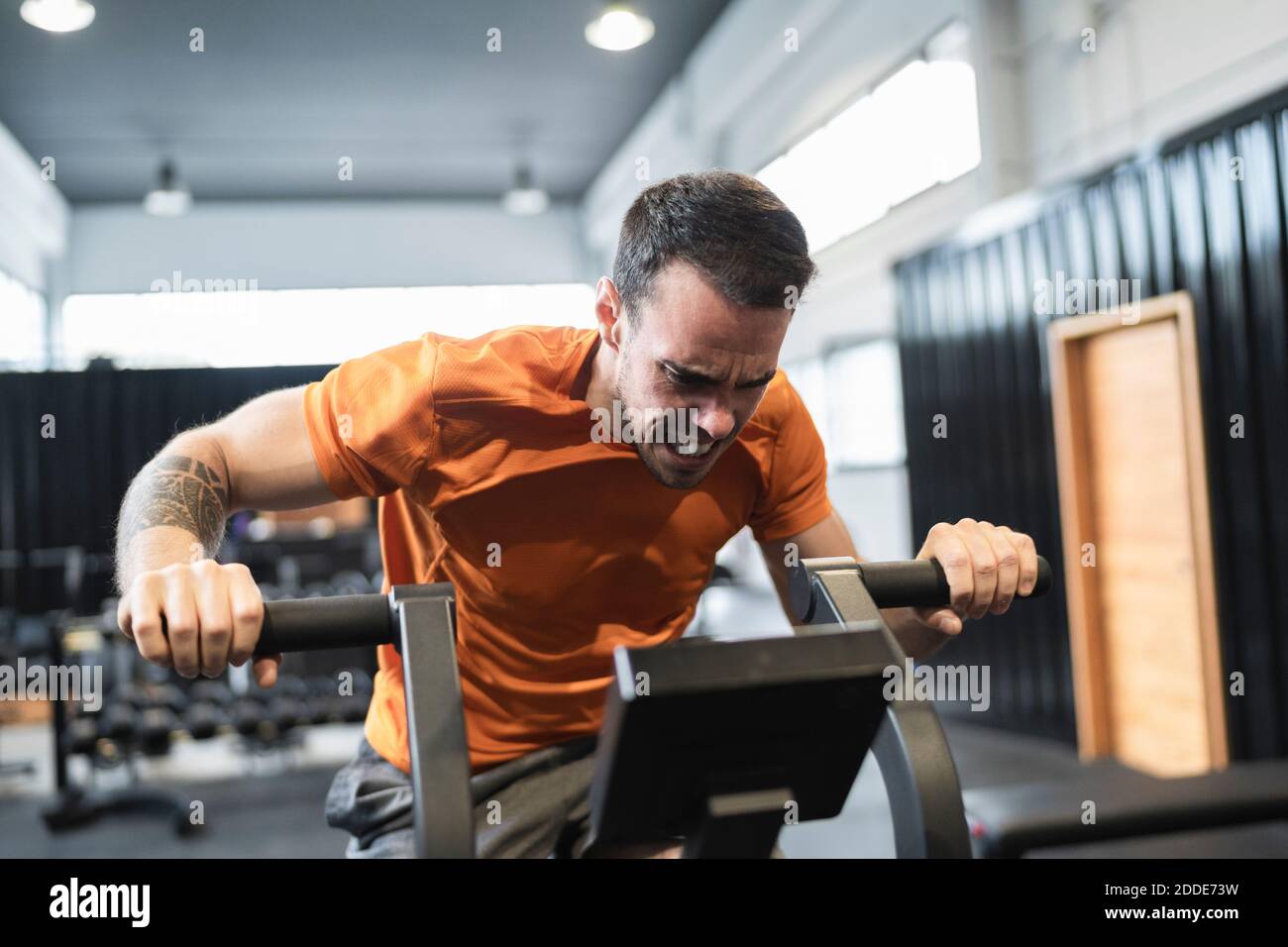 Sportsman s'entraîner sur des appareils d'exercice dans la salle de gym Banque D'Images