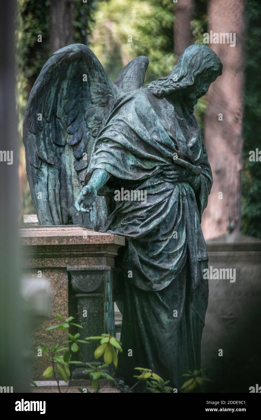 Statue d'ange patiné à côté de la tombe dans le cimetière Banque D'Images