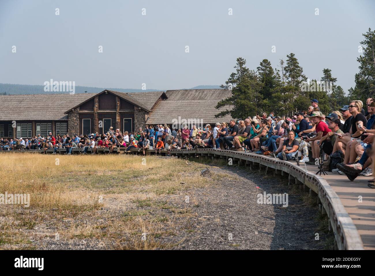 Les touristes attendent que le geyser Old Faithful éclate en face de l'Old Faithful Lodge dans le parc national de Yellowstone dans le Wyoming, Etats-Unis. Banque D'Images