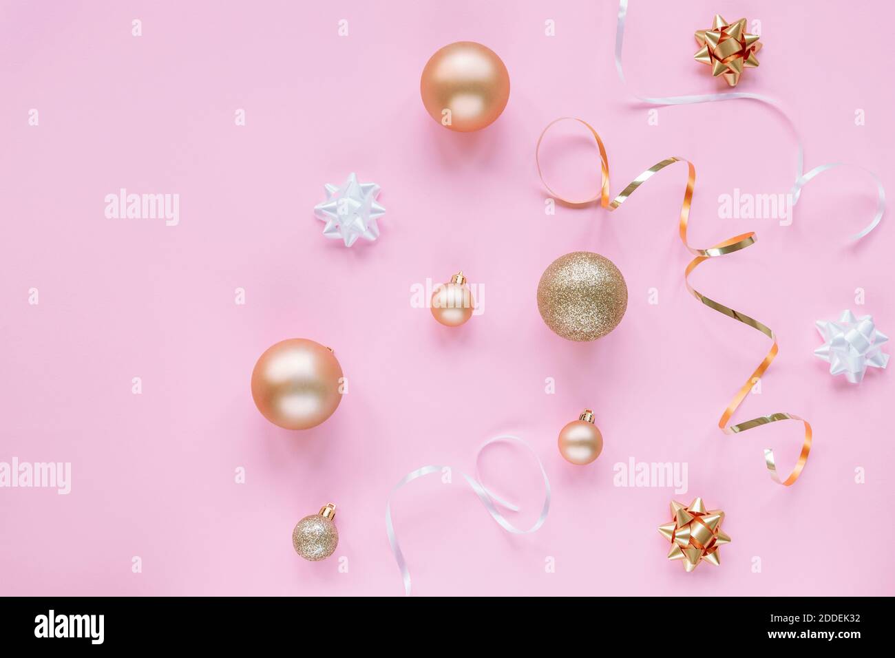 Fond de fête rose avec boules de Noël blanches et dorées, guirlande et boules. Vue de dessus, plat, espace de copie. Banque D'Images