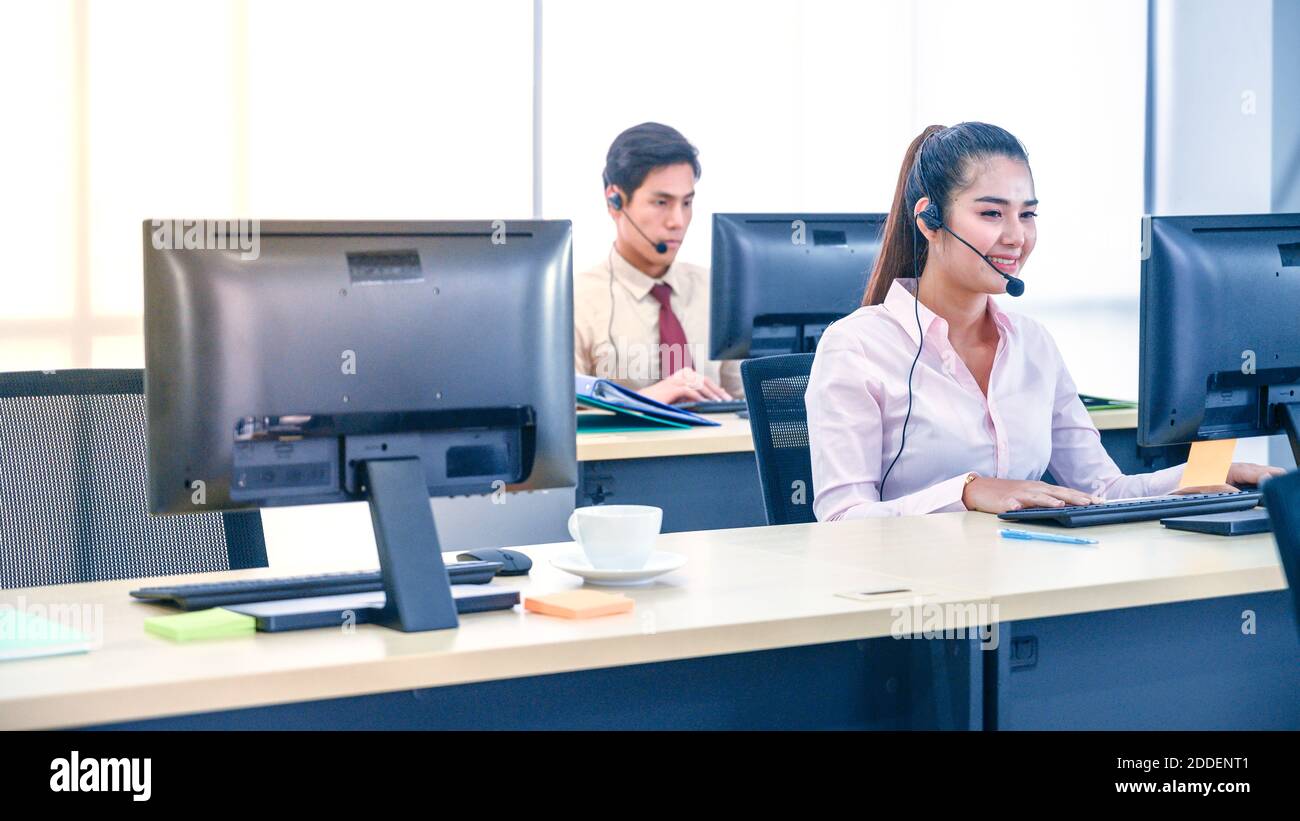 Jeunes femmes de service à la clientèle agent avec des micro-casques et ordinateur travaillant au bureau. Concept d'opérateur professionnel. Banque D'Images