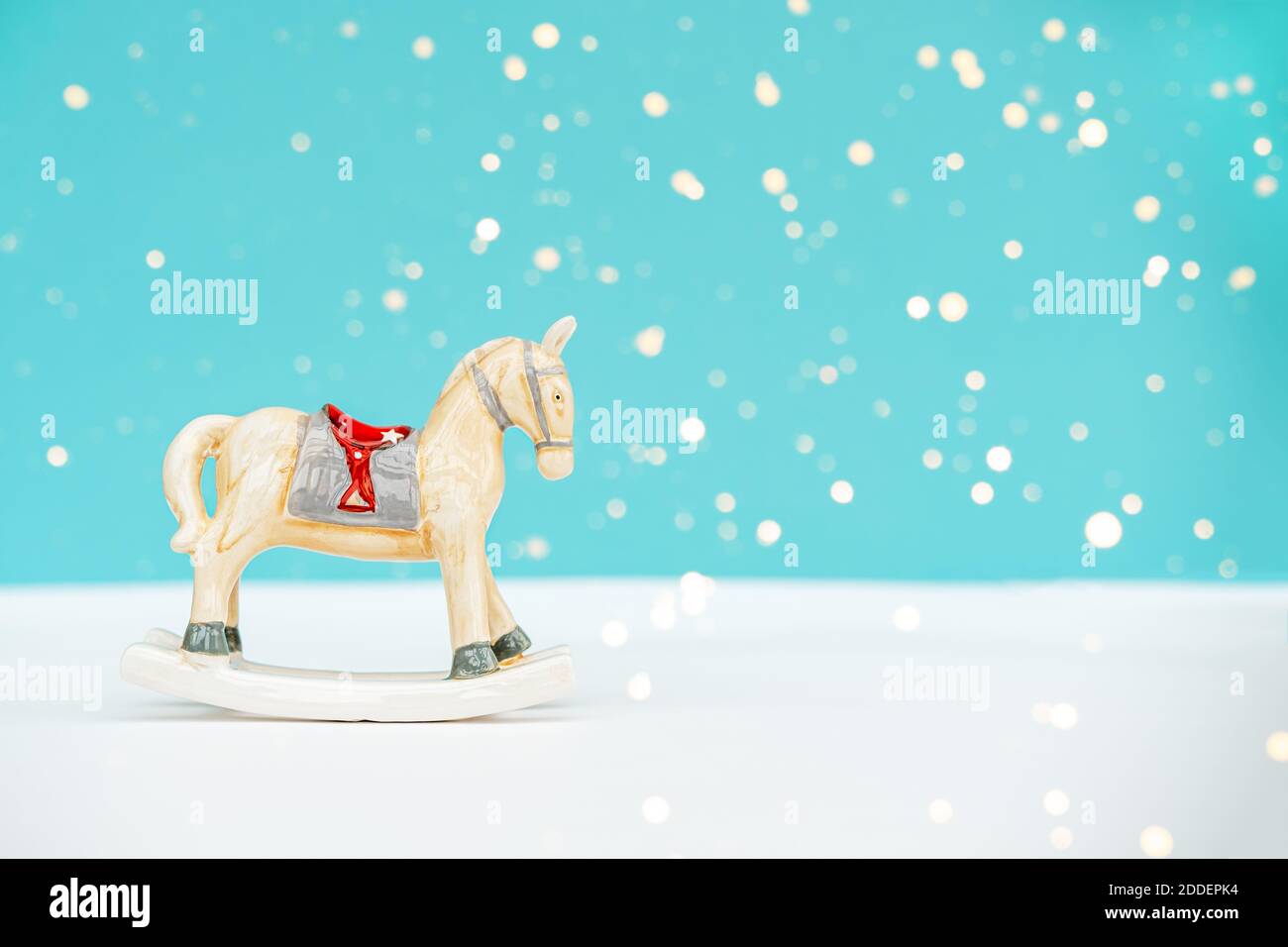 Cheval jouet de Noël sur fond bleu blanc avec lumières floues. Copier l'espace. Concept de Noël. Banque D'Images