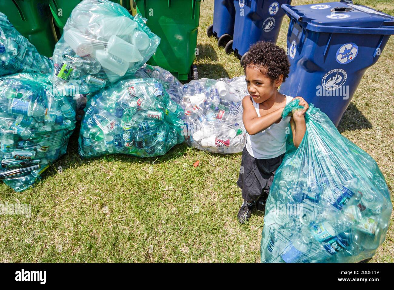 Floride ft. Fort Lauderdale Noir garçon enfant, carrys transportant des canettes recyclées sac en plastique, Banque D'Images