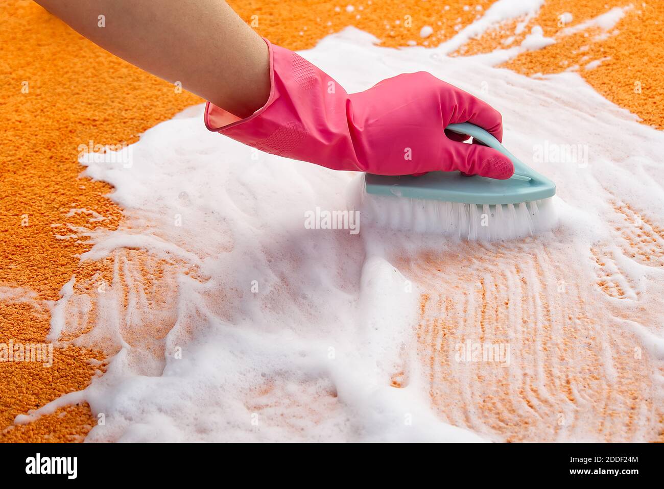 Femme nettoyage des mains taches sur le tapis avec une brosse dure.  Nettoyage de tapis orange. Concept de service de nettoyage de tapis Photo  Stock - Alamy
