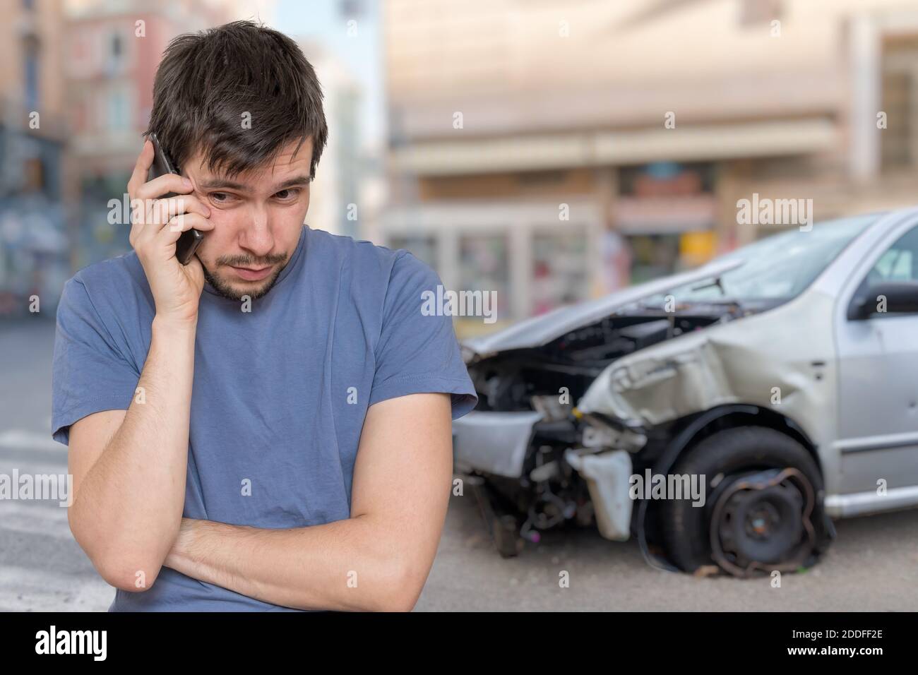 Un triste homme appelle à l'assistance après un accident de voiture. Banque D'Images