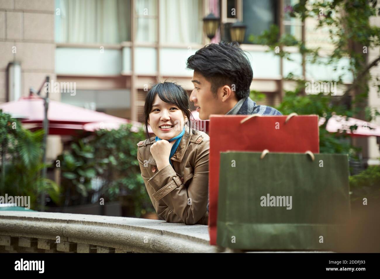 un jeune couple asiatique heureux se détendant pour bavarder à l'extérieur Banque D'Images