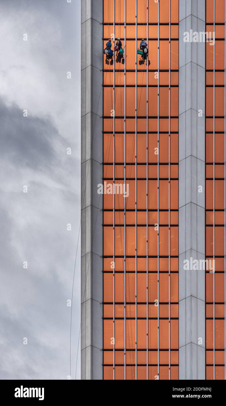 Urban Spidermen - nettoyeurs de fenêtre travaillant à la hauteur sur le façade en verre d'un gratte-ciel Banque D'Images