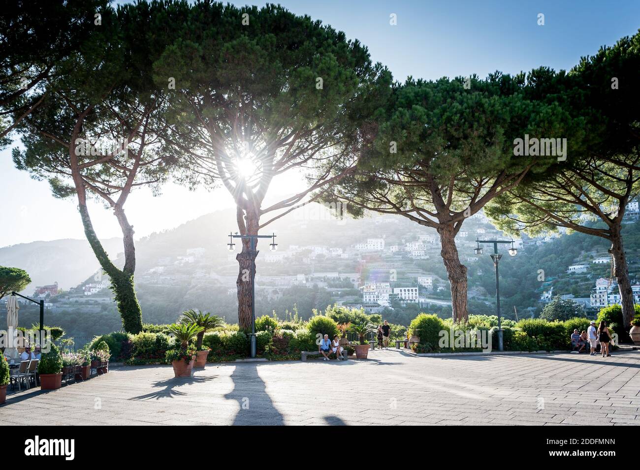 La vue sur la place principale de la ville avec la lumière du soleil venant à travers les grands arbres dans la ville de Ravello, côte amalfitaine, Italie. Banque D'Images