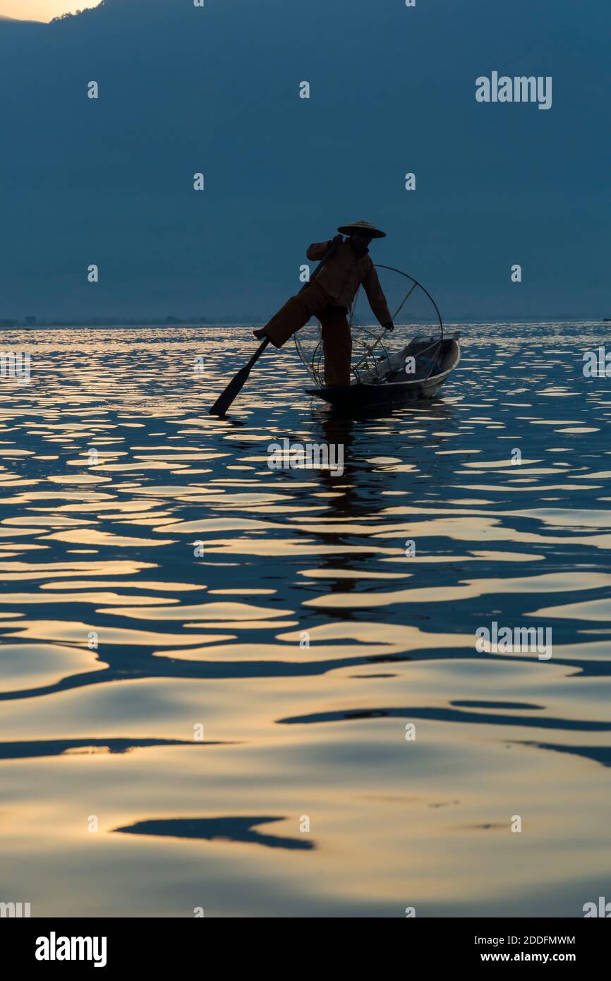 Intha Leg rameur pêcheurs à Inle Lake, Myanmar (Birmanie), Asie en février - pêcheur debout sur une jambe avirant avec l'autre Banque D'Images