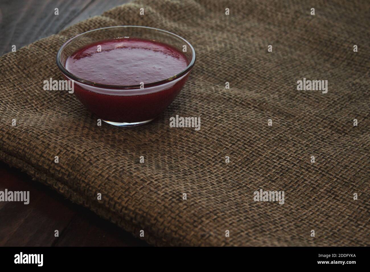 Confiture de viburnum dans un bol en verre sur la toile à sac. Concept de minimalisme Banque D'Images