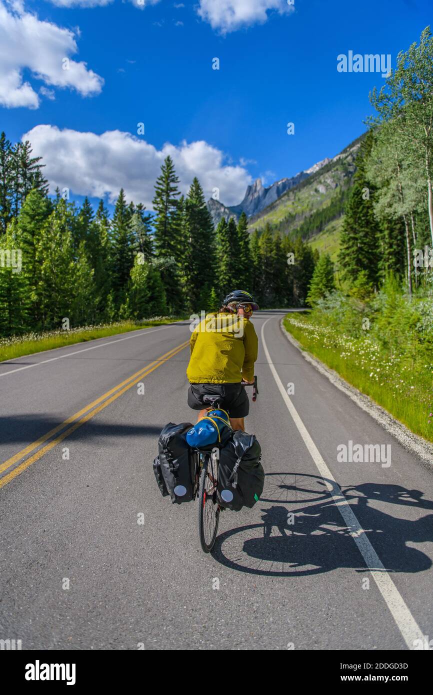 Homme faisant du vélo sur route, parc national Banff, Alberta, Canada Banque D'Images