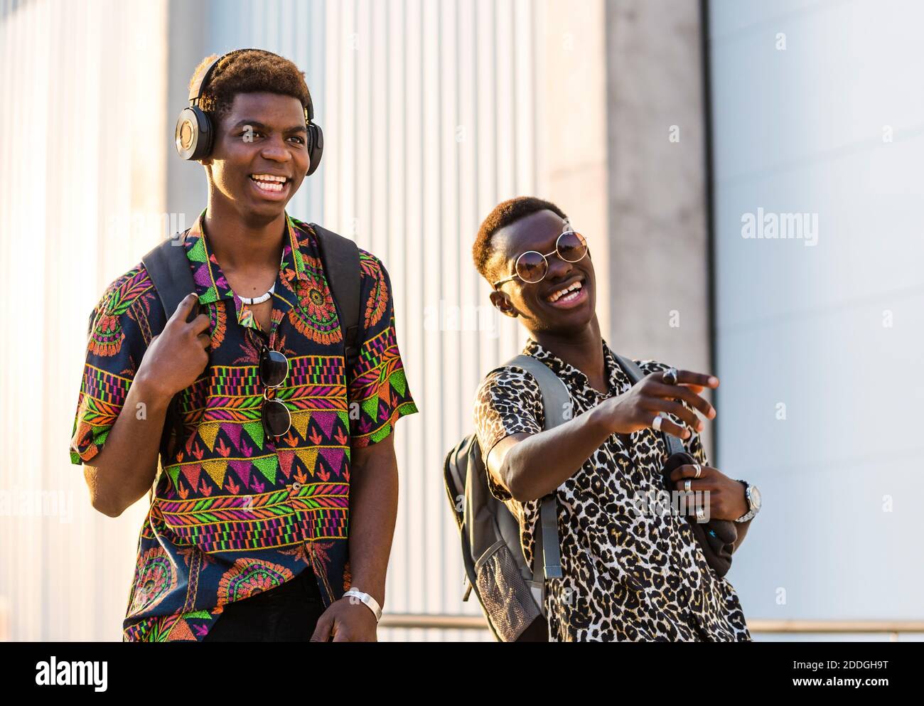 Enchantés amis africains américains dans un ensemble élégant en profitant de la promenade en ville et en riant à plaisanter ensemble Banque D'Images