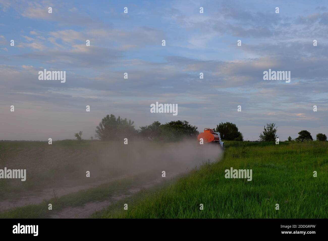 Un camion-citerne se précipitant le long d'une route de terre laissant derrière lui des nuages de poussière. Banque D'Images