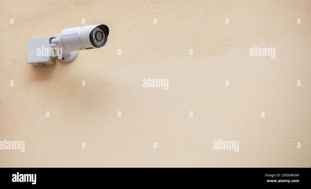 Caméra de vidéosurveillance isolée sur fond de mur beige, espace de copie Banque D'Images