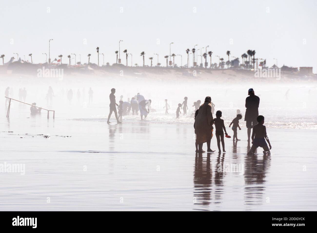 Casablanca, Maroc. Silhouettes de différentes personnes jouant au football, marchant et courant à la plage couverte de brouillard, Casablanca Beach, Maroc, Afr Banque D'Images