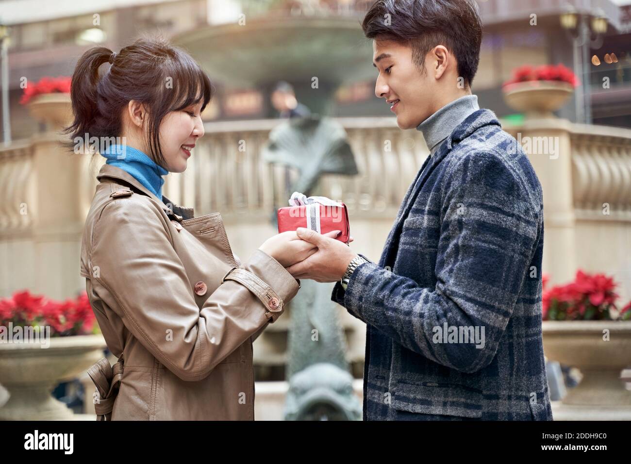 jeune homme asiatique donnant à sa petite amie un cadeau de noël ou d'anniversaire Banque D'Images