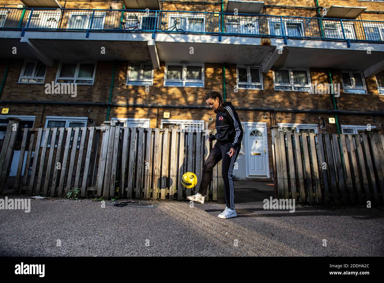 Une adolescente à l'extérieur de sa maison après avoir joué au football à l'école après qu'un blocage national du coronavirus l'a arrêtée pour son équipe de football du samedi. Banque D'Images