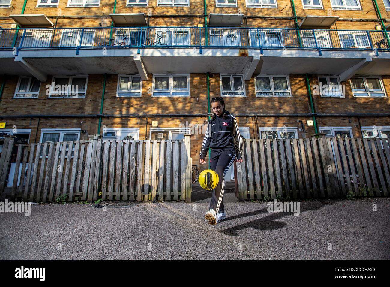 Une adolescente à l'extérieur de sa maison après avoir joué au football à l'école après qu'un blocage national du coronavirus l'a arrêtée pour son équipe de football du samedi. Banque D'Images