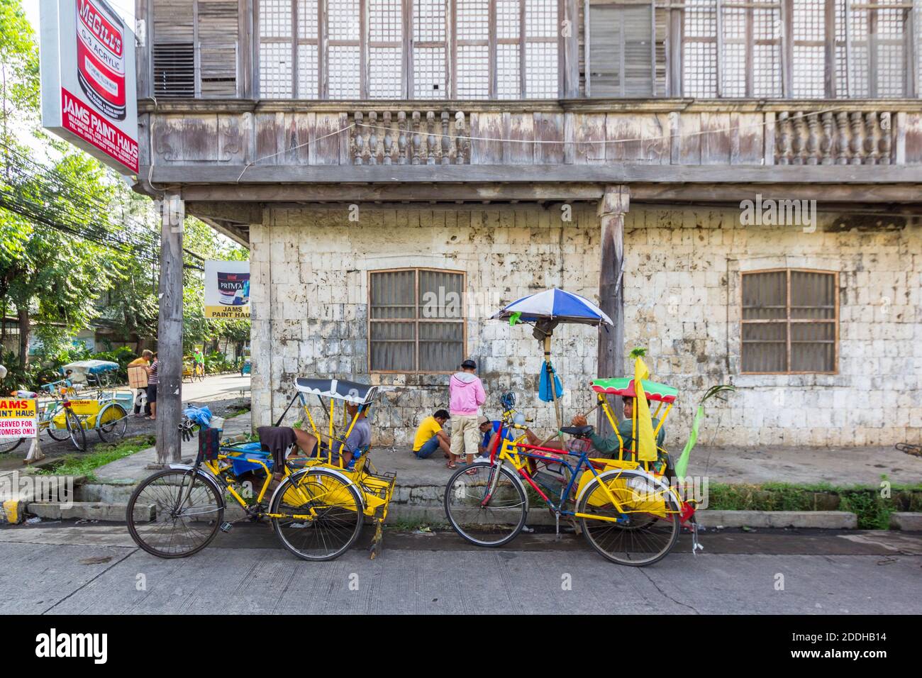 Pédicabs locaux garés à côté d'une vieille maison dans la ville d'Ozamiz, Philippines Banque D'Images