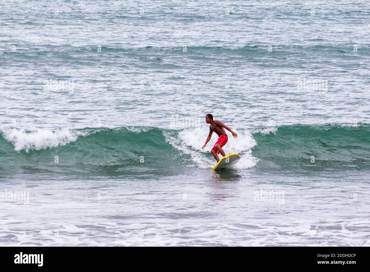 Un surfeur sur les vagues à Baler, Philippines Banque D'Images