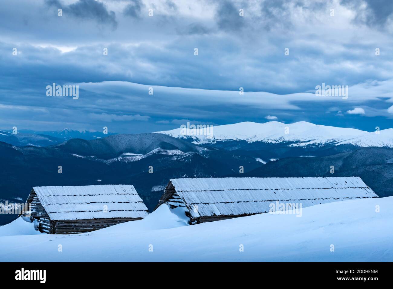 Paysage d'hiver fantastique avec des maisons en bois dans des montagnes enneigées. Concept de vacances de Noël. Montagne des Carpates, Ukraine, Europe Banque D'Images